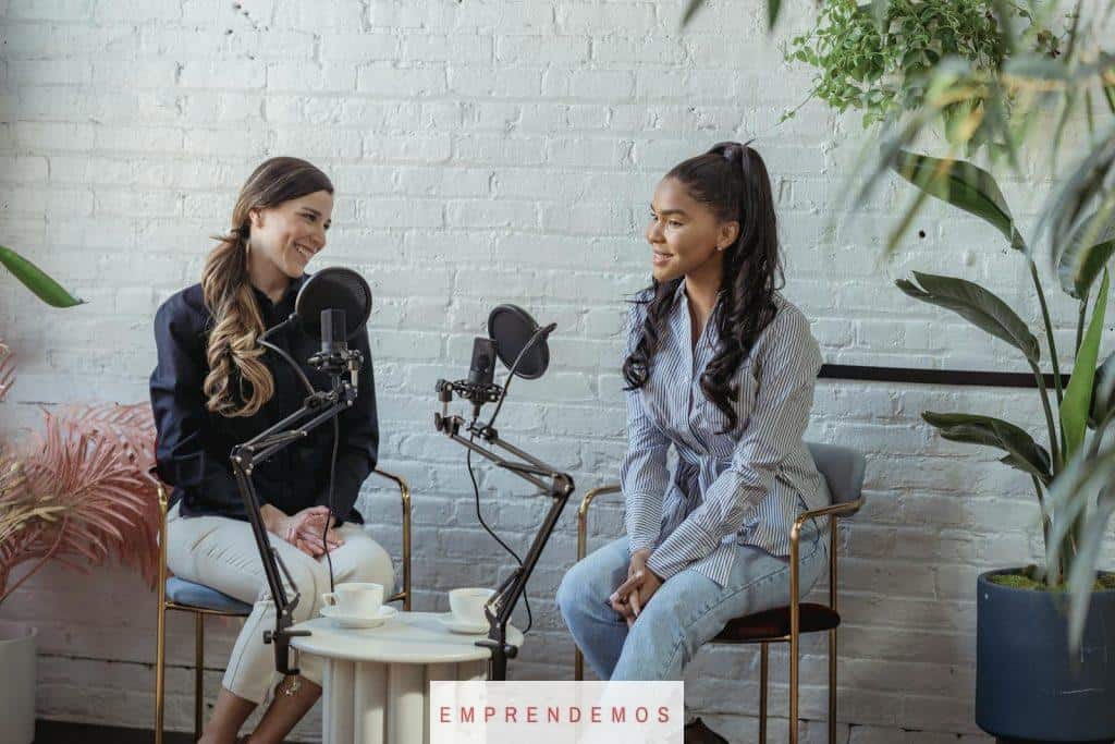 Diverse women communicating while recording voice in studio with white brick walls in daytime