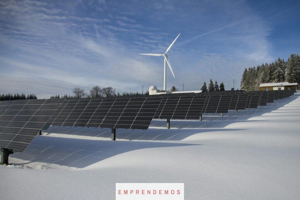 Solar Panels on Snow With Windmill Under Clear Day Sky