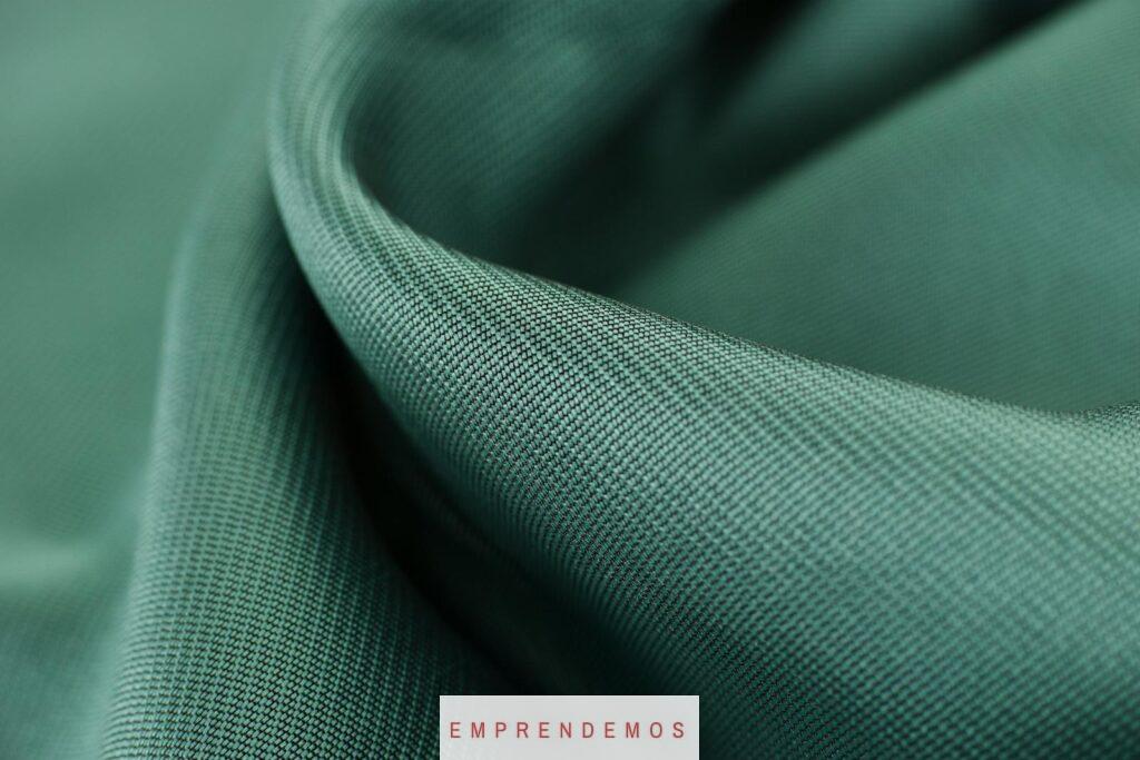 Close-up texture shot of elegant green satin fabric highlighting its smooth and soft surface.