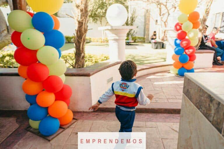 Boy in paw patrol jacket runs past colorful balloons